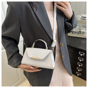 Détail du sac à main blanc motif crocodile avec une boucle en métal doré élégante