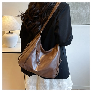 Close-up of vintage brown leather tote bag with functional side metal zipper and puller
