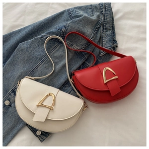 Close-up of saddle shoulder bags in white and red leather with gold D-ring buckle