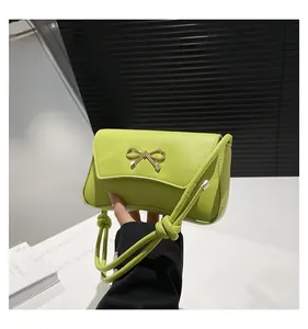 Detailed close-up of lime green leather bag with elegant gold bow metal fastener