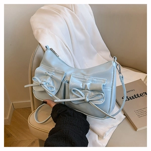 Vue détaillée du sac à bandoulière bleu clair avec poches à nœuds et texture en cuir PU