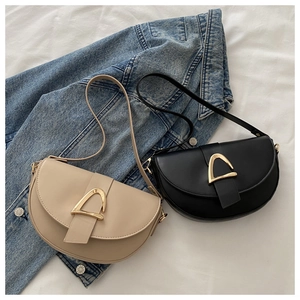 Chic beige and black half-moon saddle bags featuring trendy gold triangle buckles