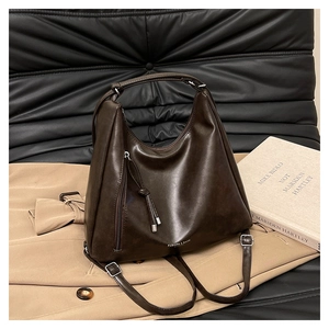 Détail du sac vintage marron foncé en similicuir avec fermeture éclair latérale et frange