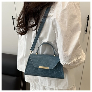 Sac bandoulière bleu motif crocodile avec boucle dorée porté, vue de côté sur mannequin