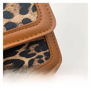 Detailed close-up of leopard print fabric texture and premium brown leather stitching