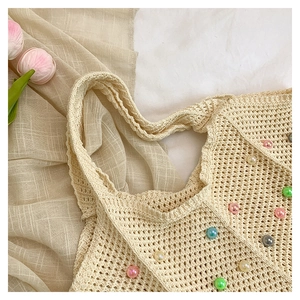 Detail of crochet cotton tote bag featuring mesh texture and colorful pearl beads
