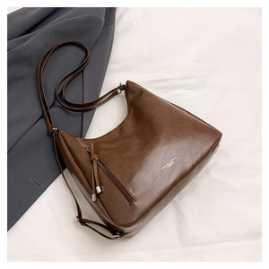 Detailed view of brown hobo bag with fringe zipper and fashion branding text