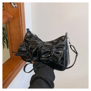 Gros plan du sac en cuir verni noir brillant avec d'élégantes doubles décorations nœud