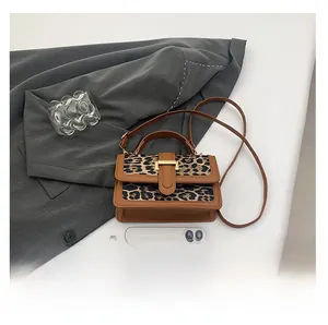 Mini leopard print crossbody bag compared with phone for size perspective