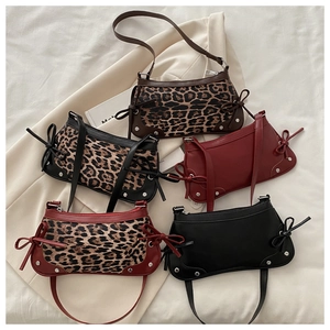 Detail of five vintage baguette bags with leopard print and rivet accents on beige fabric