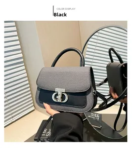 Détail du sac à main bicolore avec boucle dorée, texture cuir et poignée arrondie