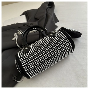 Detail of black rhinestone cylinder bag with metallic chain and matching mini pouch
