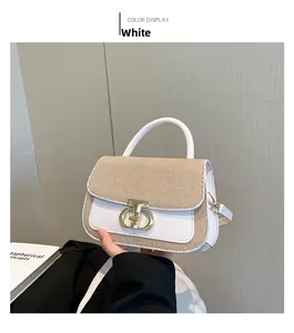 Détail d'un sac à main pour femme avec boucle métallique dorée et texture tissée bicolore