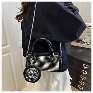 Detail of black Boston bag with silver studs and small round pouch on chain strap
