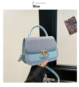 Détail du sac bandoulière en denim bleu clair avec fermoir doré métallique élégant