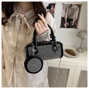 Detail of black cylinder bag with silver rivets and matching round mini coin purse charm