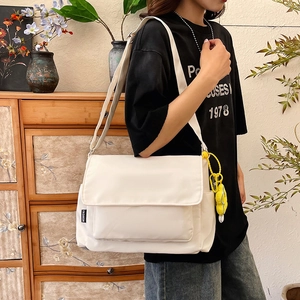 Weiße Nylon Umhängetasche mit Kontrastetikett und Blumenanhänger im minimalistischen Stil
