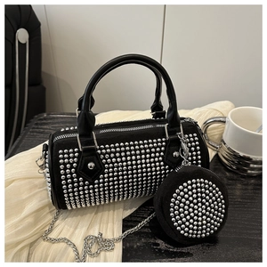 Detail of black suede cylinder bag with silver studs, chain strap and small round pouch