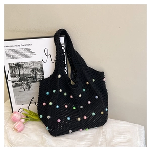 Close-up of black woven tote bag featuring colorful faux pearls and crochet texture