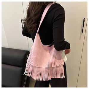 Detail of pink hobo bag featuring long stylish leather fringes and textured surface