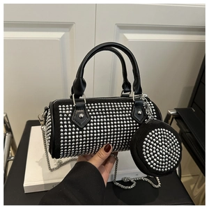 Detail of black cylinder handbag with silver studs, chain strap and small round pouch