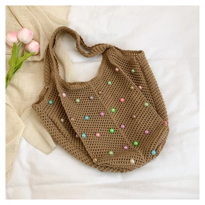 Close-up of brown crochet tote bag with colorful faux pearls on white background