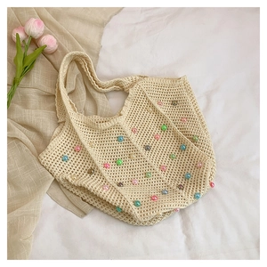 Close-up of handmade crochet tote bag featuring vibrant colorful pearls and cotton textures