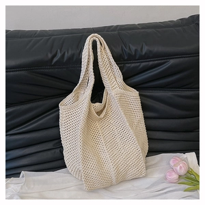 Gros plan du sac cabas en maille beige montrant la texture crochetée ajourée détaillée