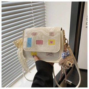 Close-up of marble pattern square bag with cartoon stickers and a plush bear charm