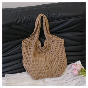 Détail du sac cabas en maille crochet beige avec motif ajouré sur tissu blanc et tulipes