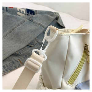 Close-up of durable white nylon strap with plastic hook and yellow zipper detail