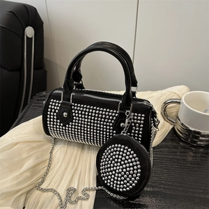Black cylindrical barrel bag with silver studs, metal chain strap and mini coin purse