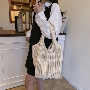 Beige crochet knit tote bag with hollow design for casual shoulder wear by a model