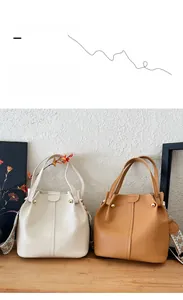 Detailed view of large vintage bucket bags in beige and brown with woven ethnic straps