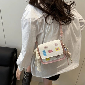 Fashionable white tote bag with pink trim, colorful graffiti stickers and plush pendant
