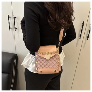 Détail du mini sac jacquard rose avec boucle cœur dorée et bandoulière large rose
