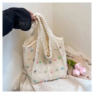 Detail of woven tote bag with colorful pearls, flowers and book in French style setting