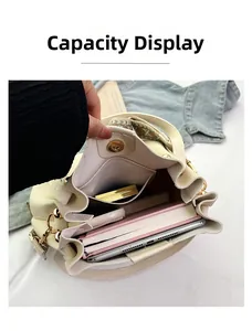 Capacity display of large creamy bucket bag with geometric strap and interior items