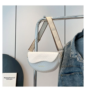 Close-up of white saddle bag showing woven texture and two-tone wide canvas strap