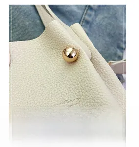 Detail of a golden spherical clasp on high-quality off-white lychee grain leather
