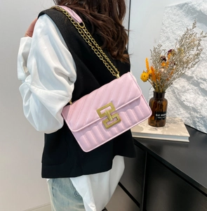 Close-up of pink V-quilted leather crossbody bag with elegant gold chain and square buckle