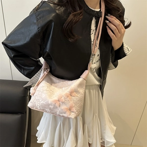 Sac bandoulière en dentelle rose avec nœuds 3D et strass porté par un mannequin