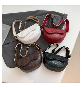 Detailed top view of four textured saddle bags in cream, burgundy, brown and black leather