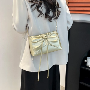 Chic light gold ballet-style crossbody bag with large bow and elegant chain strap