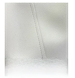 Close-up of white litchi grain leather texture and precise stitching on the bucket bag