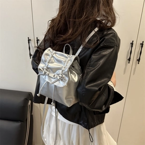 Chic silver metallic mini backpack for women featuring stylish bow details and drawstring