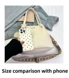 Size comparison of a cream-colored leather tote bag next to a mobile phone