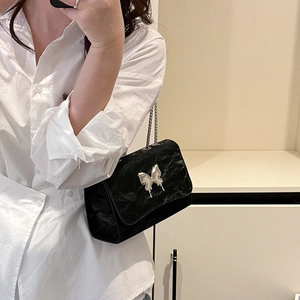 Chic black pleated shoulder bag featuring a silver butterfly buckle and metal chain strap