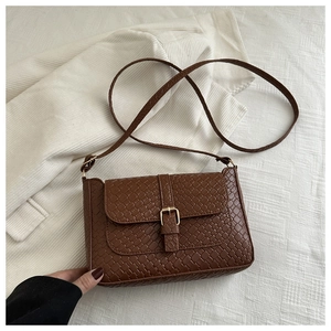 Detailed view of brown woven texture PU leather crossbody bag with gold metal buckle