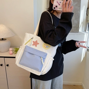 Large white canvas tote bag with blue front pocket and pink star patch for school girls